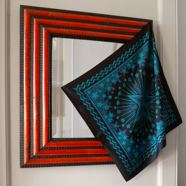 Blue, Turqoise & Black hand printed silk bandana featuring a constellation of stars designed for a Country & Western party draped over an ornate red & black mirror like a work of art in fabric in a grand London townhouse